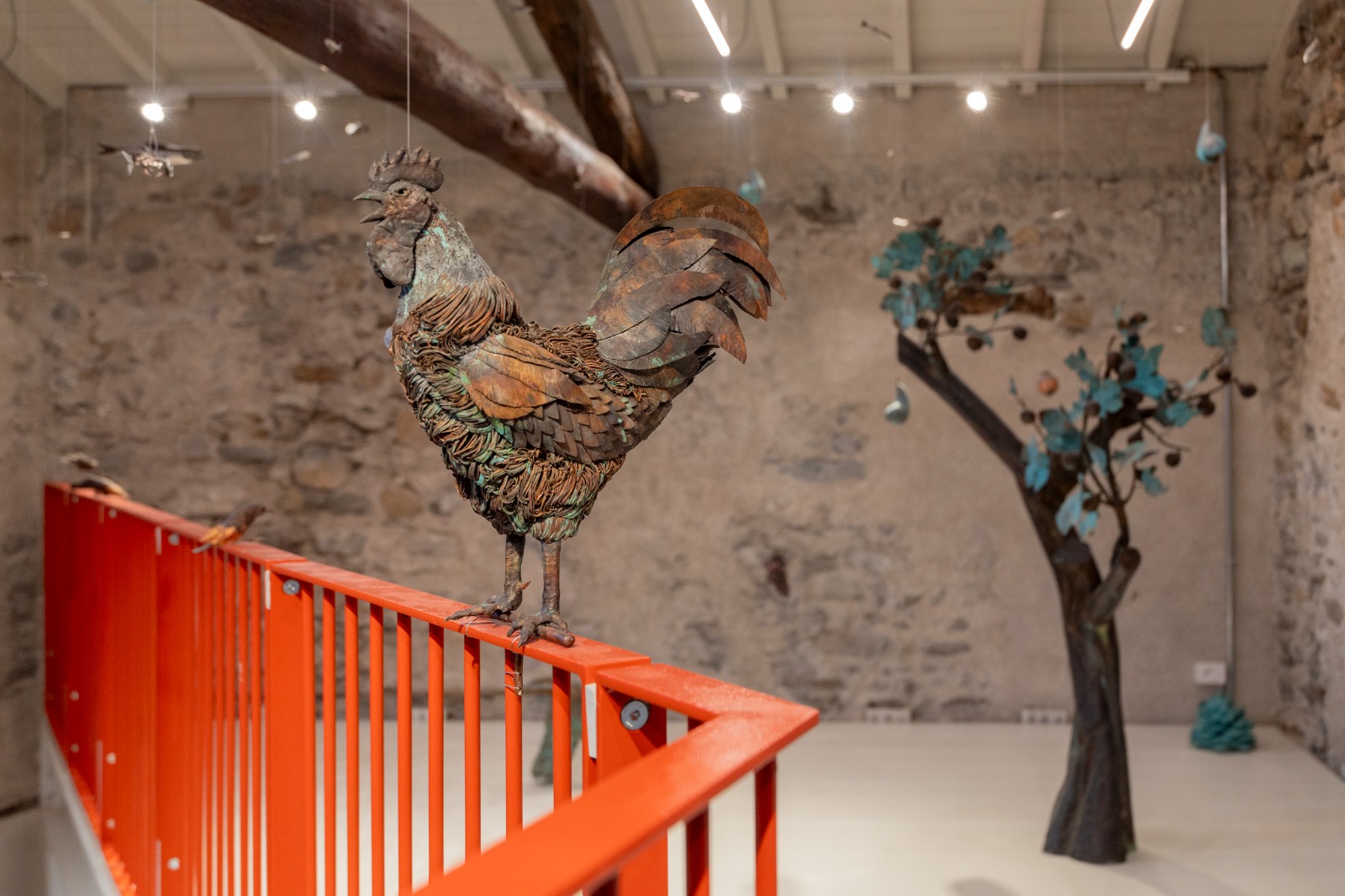 gallo in metallo su ringhiera arancione